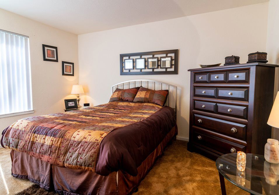 a bedroom with a king size bed and a dresser at Camelot Place.