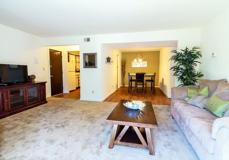 a living room with a couch , coffee table , and television at Camelot Place.