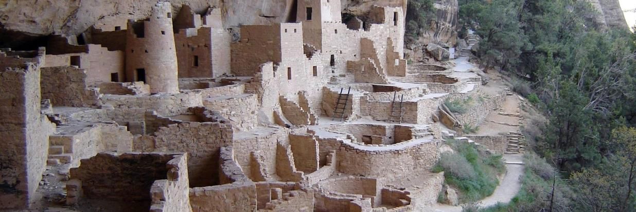 A group of ancient buildings sitting on top of a cliff.