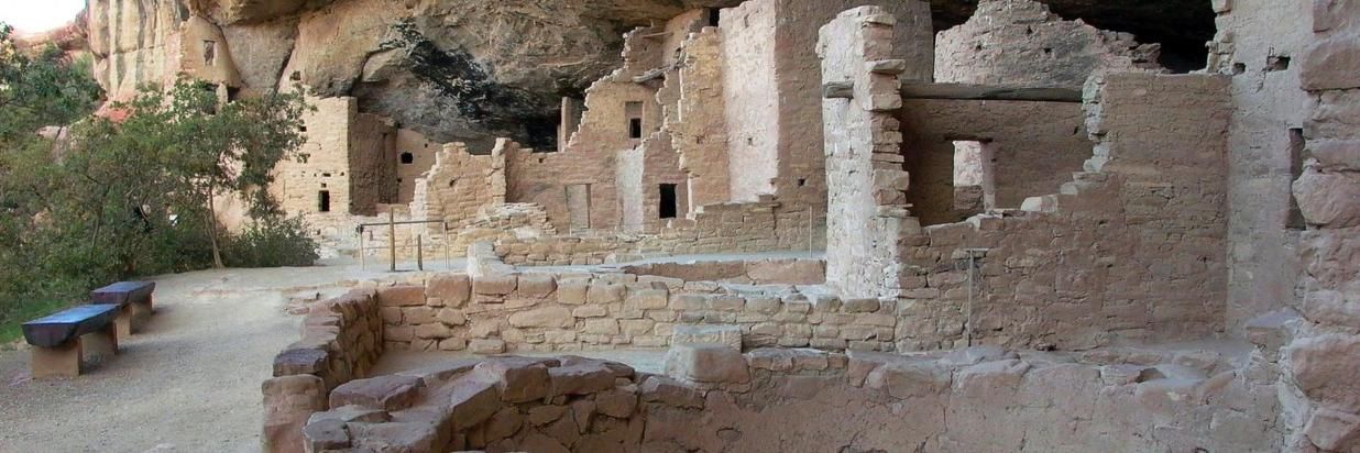 A group of ancient ruins sitting on top of a rocky hillside.