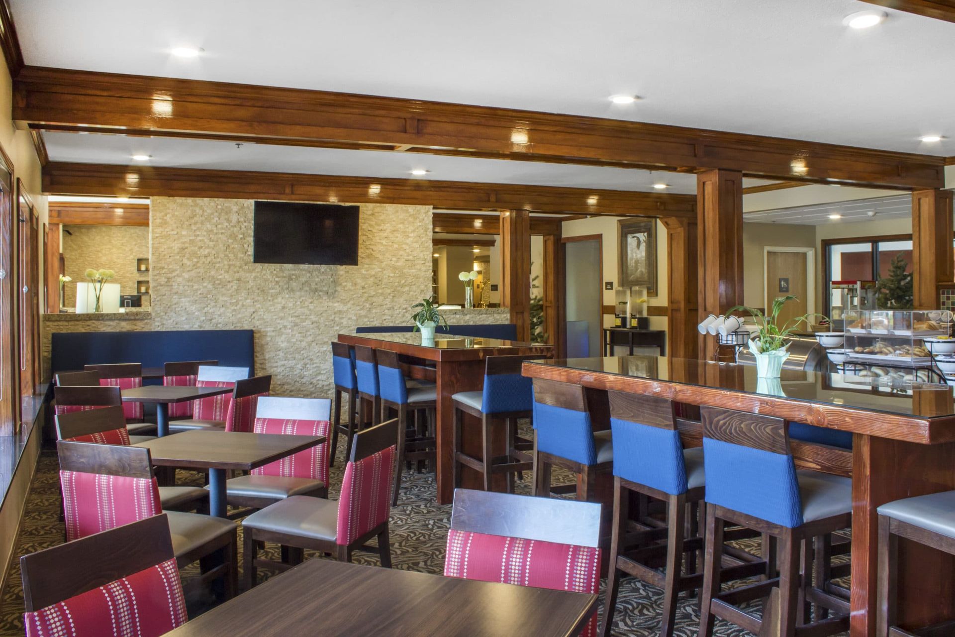 A restaurant with tables and chairs and a bar.