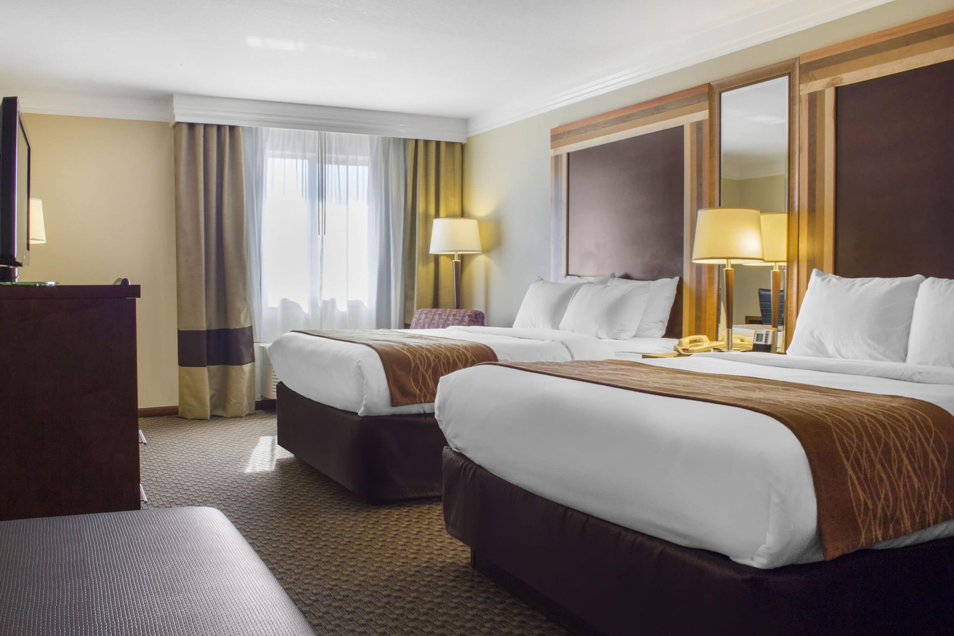 A hotel room with two beds and a television