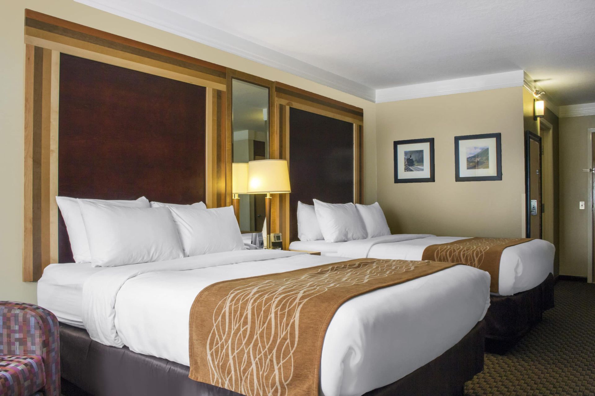 A hotel room with two beds and a chair