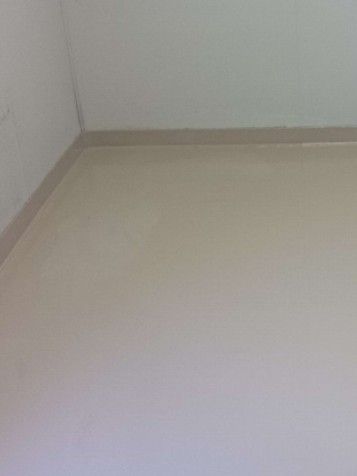 Empty white room corner with beige baseboard and tiled floor