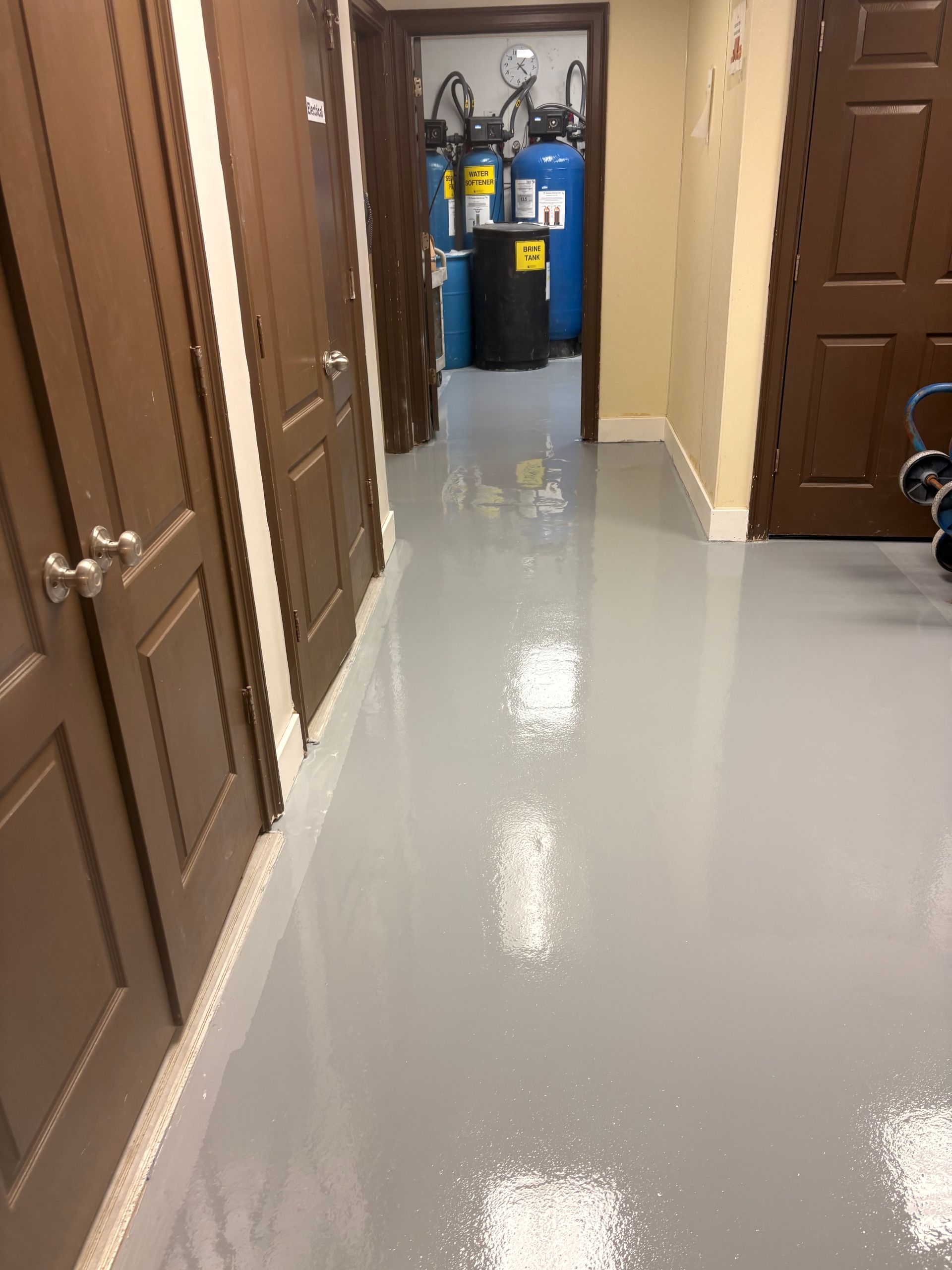 Person smoothing gray concrete with a trowel on a floor surface
