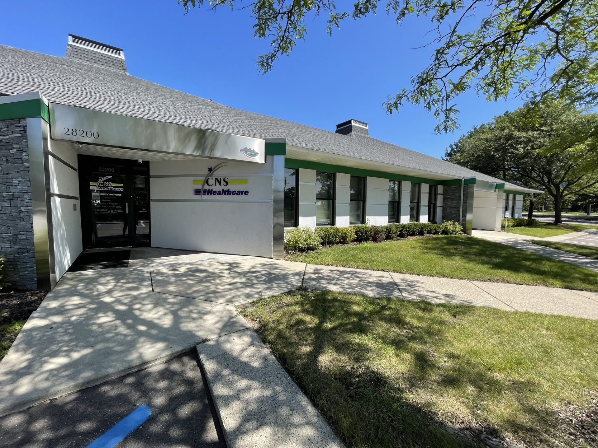 A large white building with a gray roof and green trim