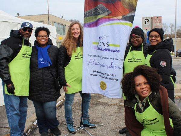 A group of people standing in front of a banner that says cns healthcare