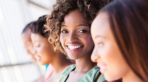 A group of women are standing next to each other and smiling.