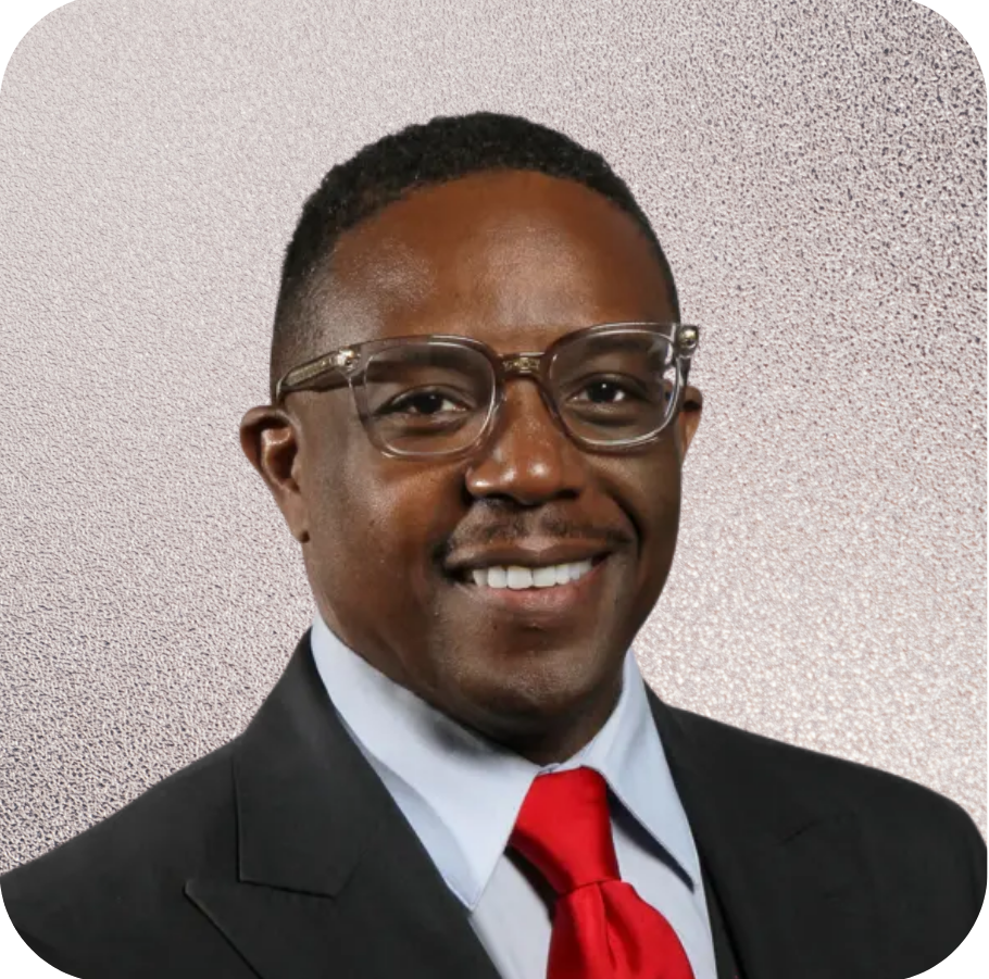 A man wearing glasses and a red tie smiles for the camera