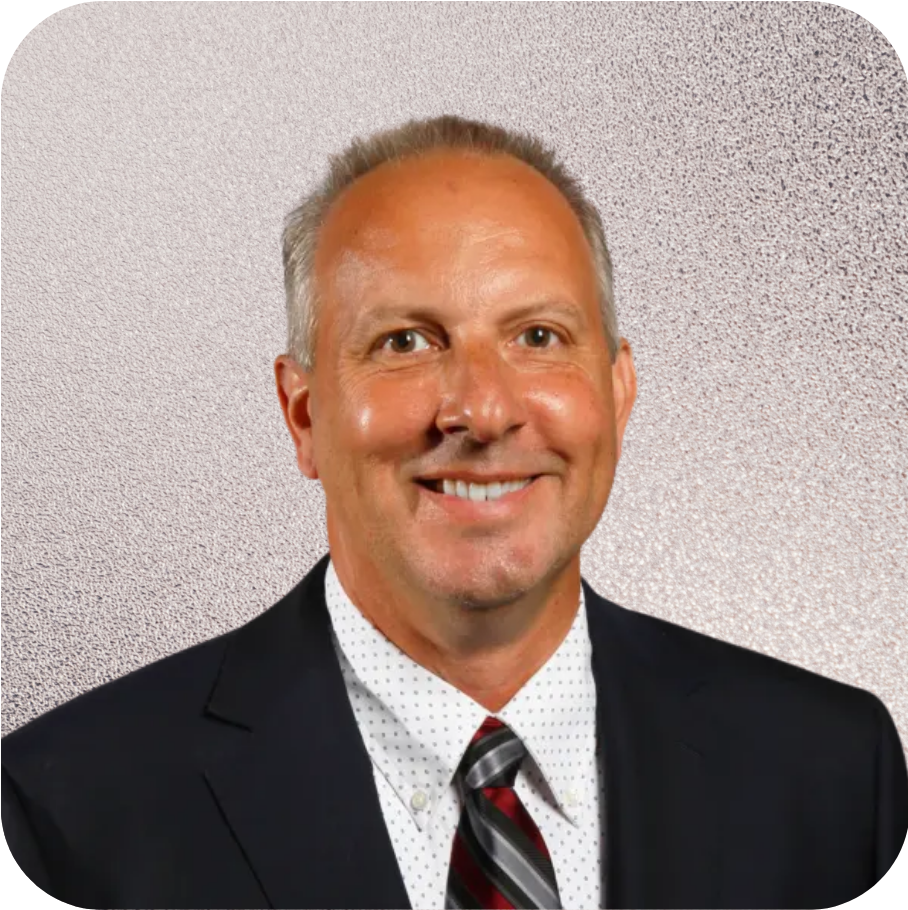 A man in a suit and tie is smiling for the camera