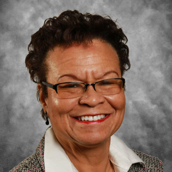 A woman wearing glasses is smiling for the camera