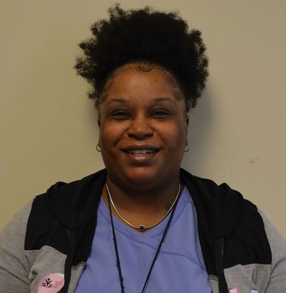 A woman wearing a blue northeast jacket smiles for the camera