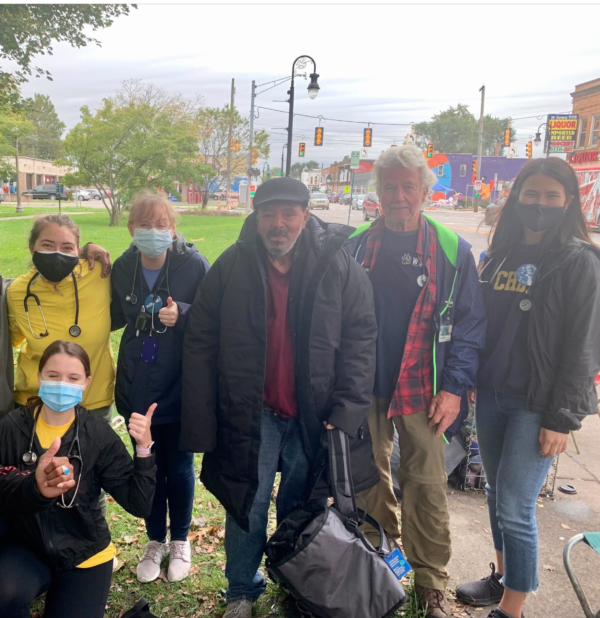 A group of people wearing face masks are posing for a picture