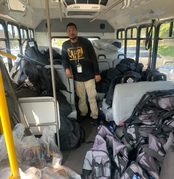 A man wearing a shirt that says calpa is standing in a bus