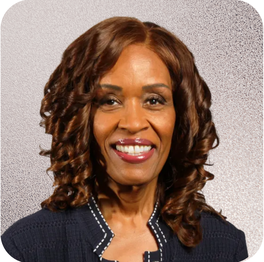 A woman with curly hair is smiling for the camera