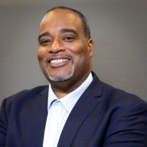 A man in a suit and tie is smiling for the camera.