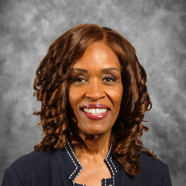 A woman with curly hair is smiling for the camera