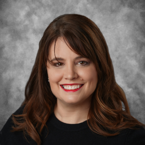 A woman wearing a black shirt and red lipstick smiles for the camera