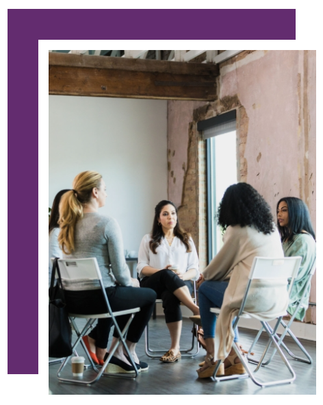 A group of women are sitting in a circle talking to each other.