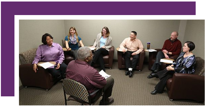 A group of people are sitting in a circle in a room.