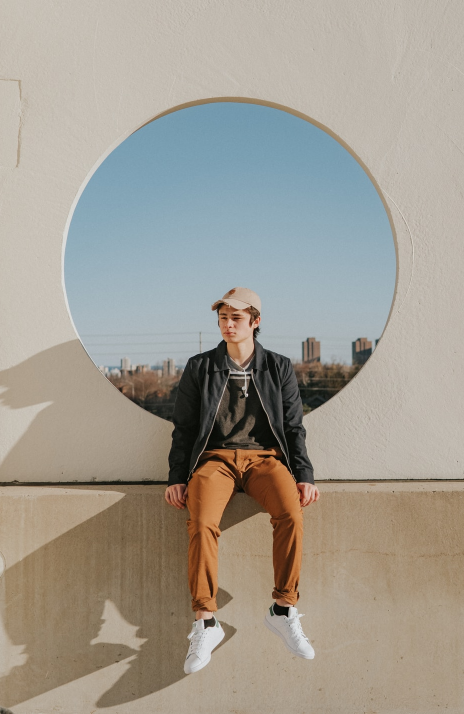 A man is sitting in a circle on a wall.