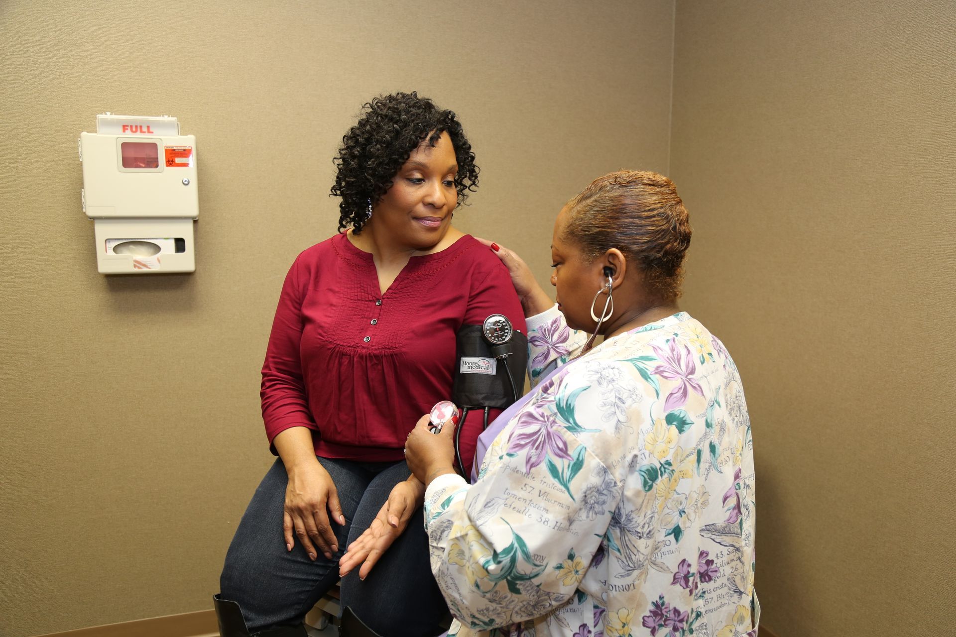 A woman gets her blood pressure checked by a nurse.