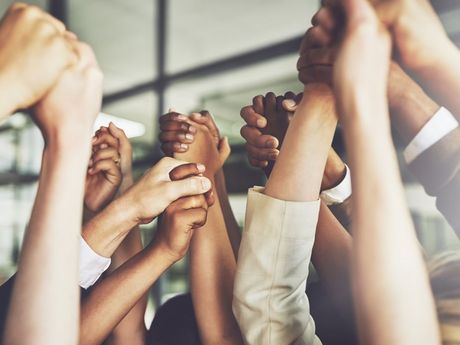 A group of people are holding their hands up in the air.