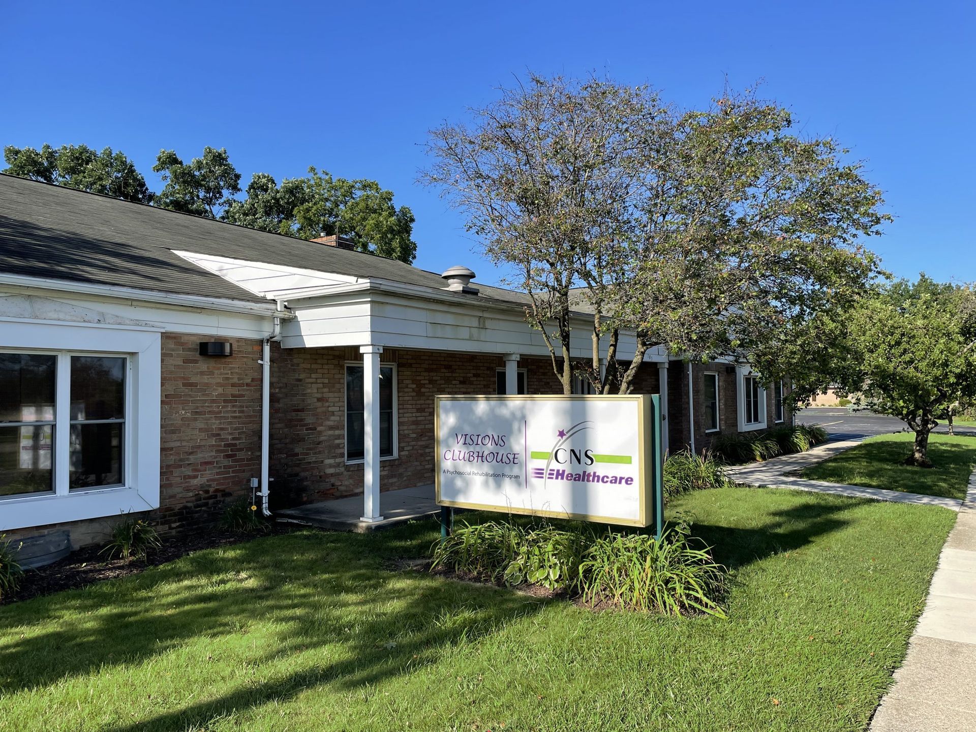 A large brick building with a sign in front of it.