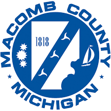 A blue and white logo for macomb county michigan