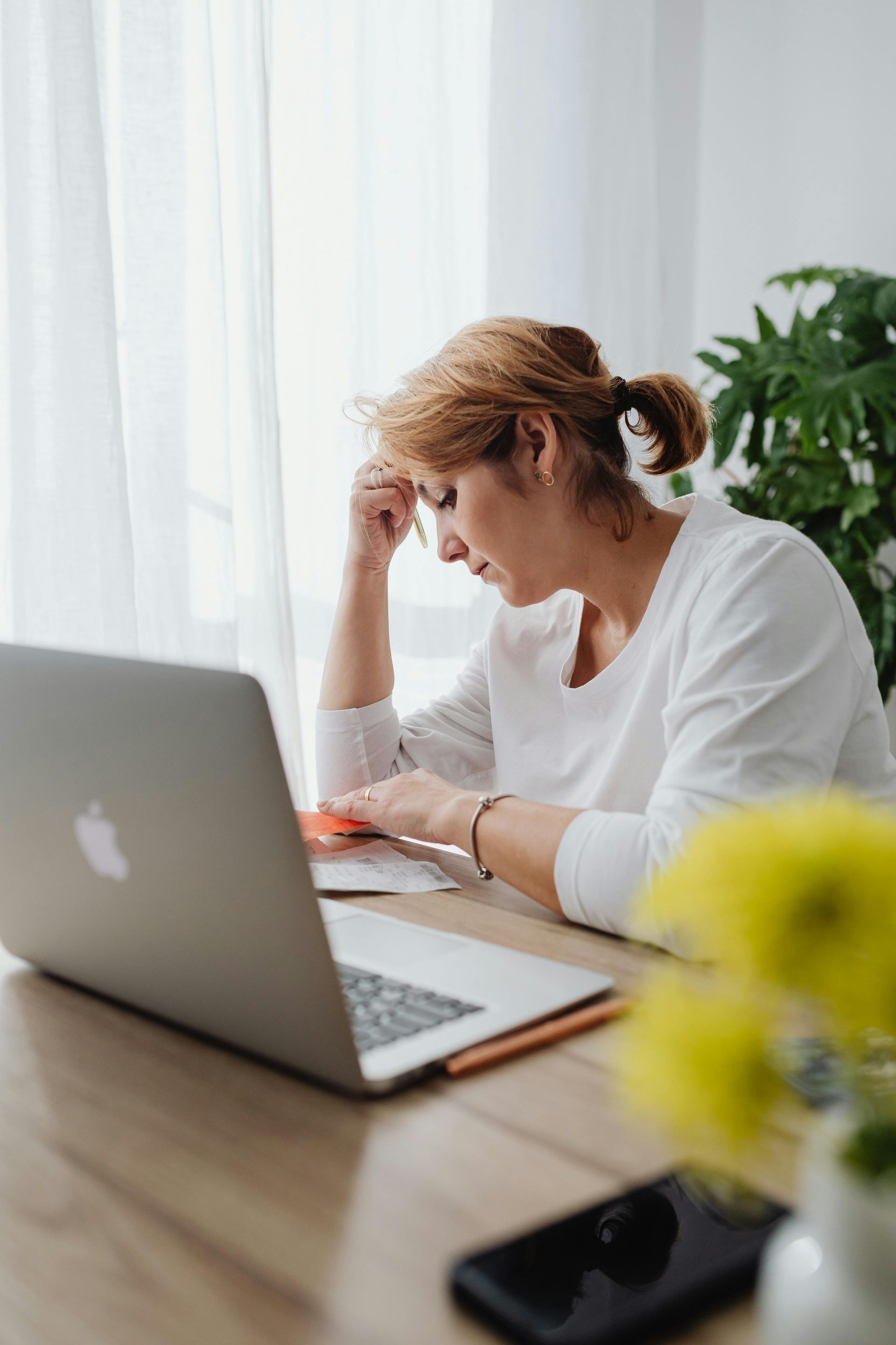 A woman is sitting at a desk using a laptop computer.