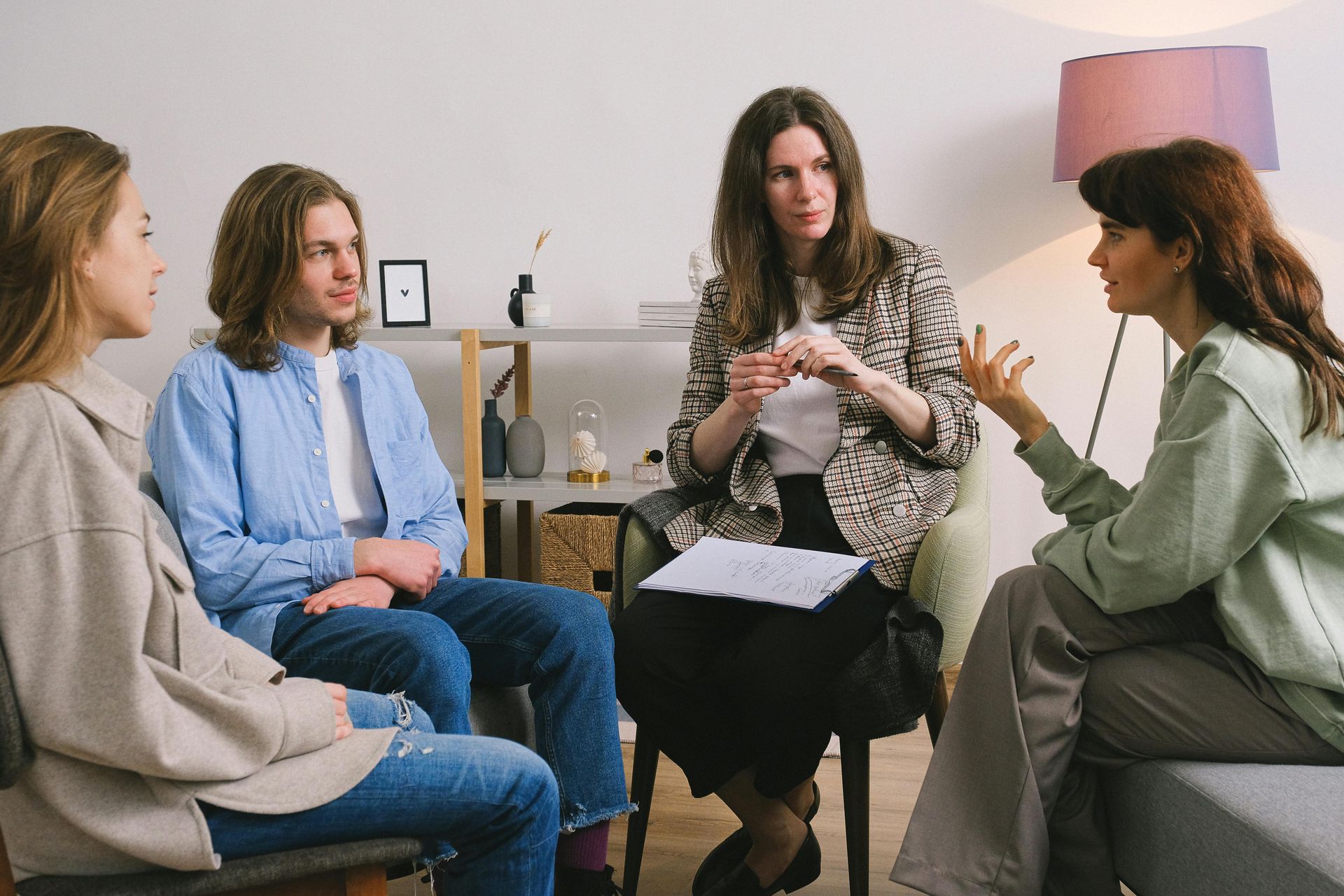 A group of people are sitting in a circle talking to each other.