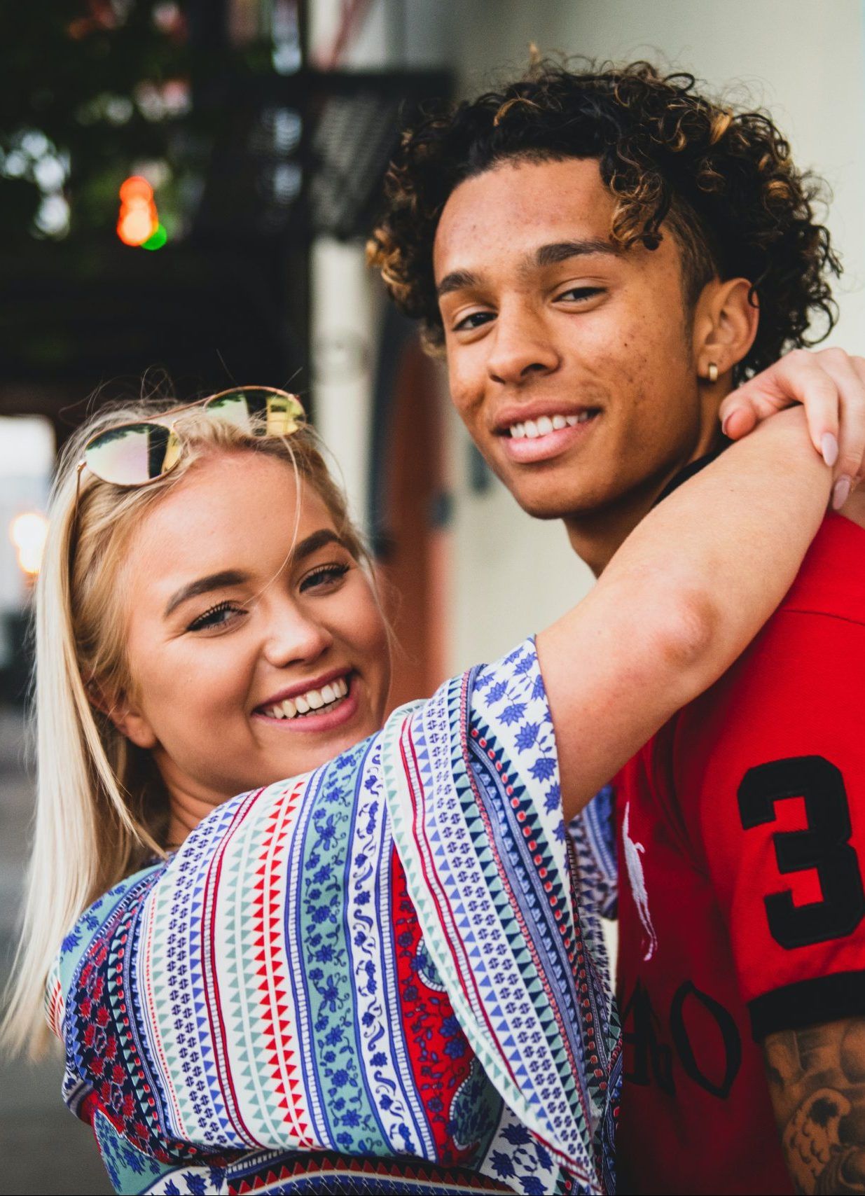 A man and a woman are hugging each other and smiling.