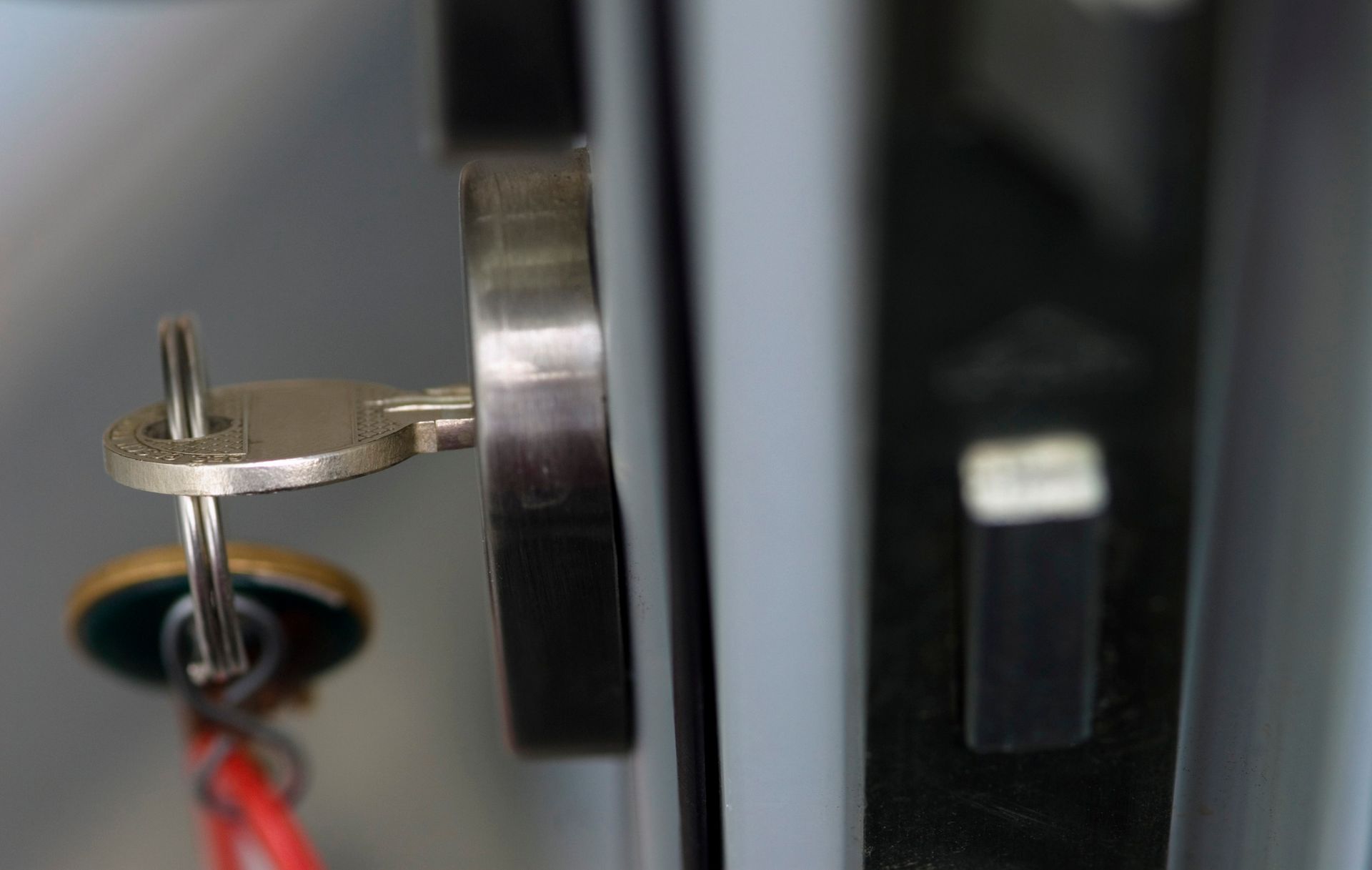 A white house with a red alarm on the side of it.