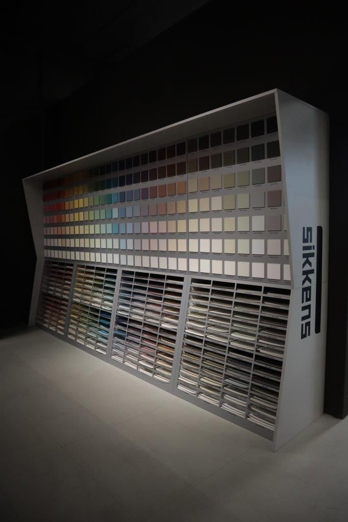 Una mostra di colori di vernice Sikkens in una stanza buia