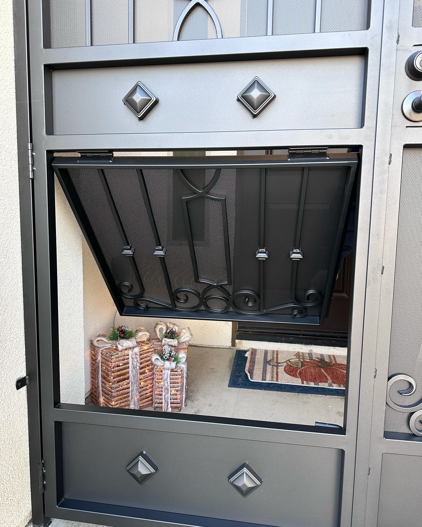 A wrought iron gate with a shelf underneath it