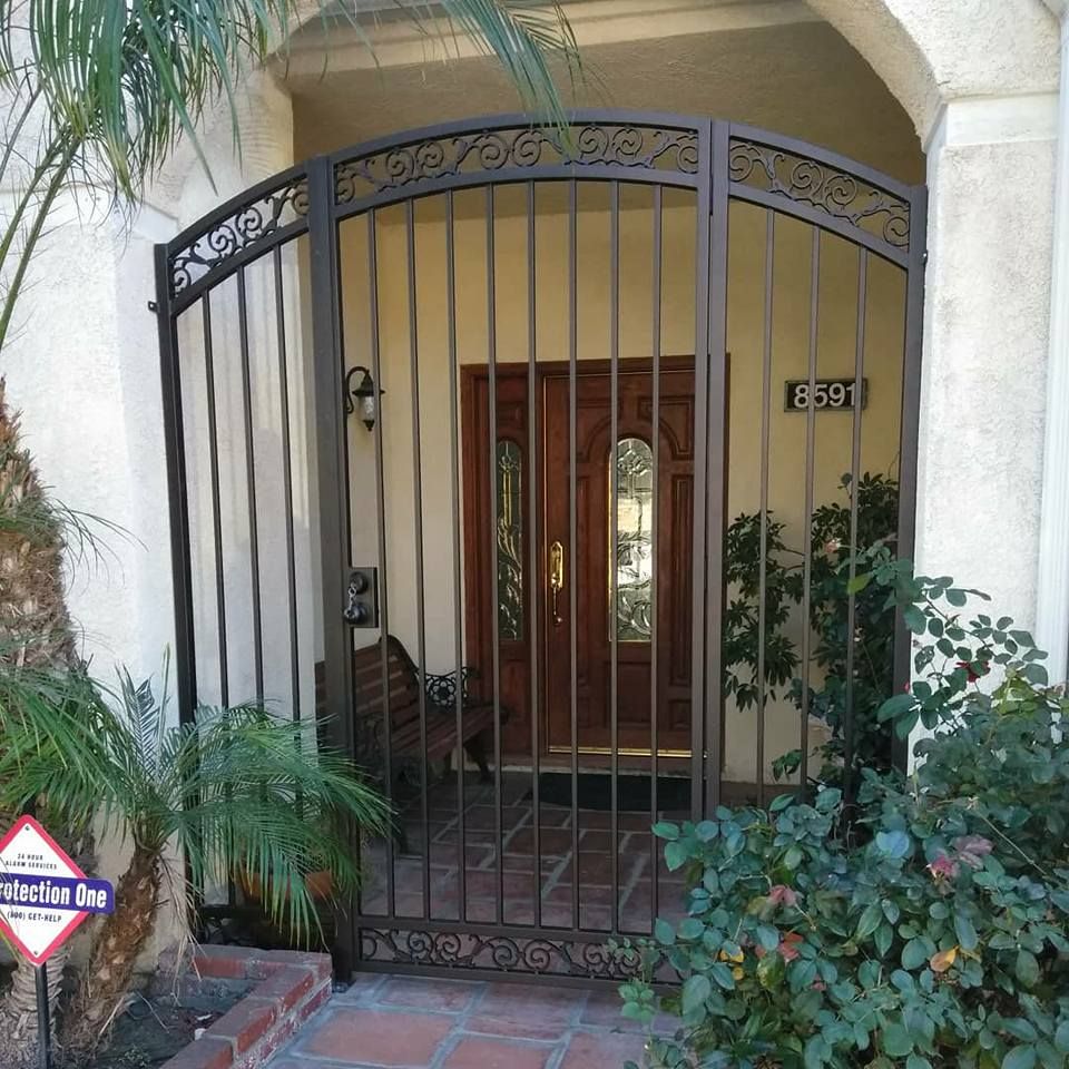 A wrought iron gate surrounds the entrance to a house