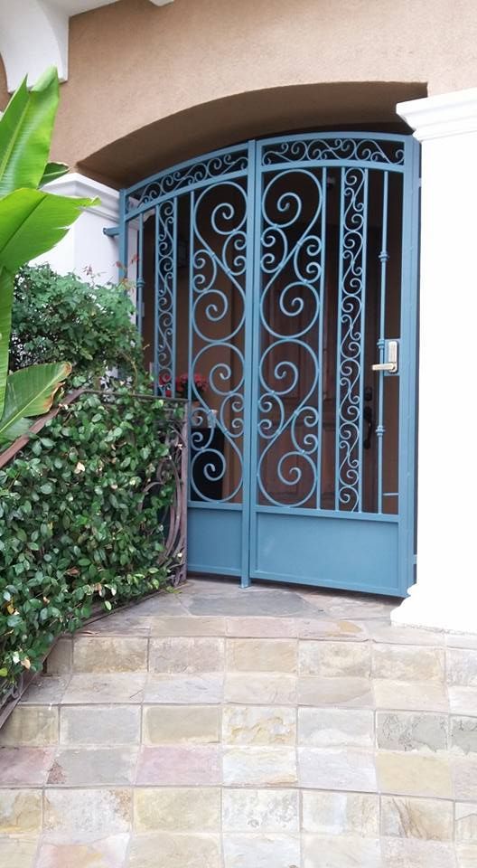 A blue wrought iron gate is sitting in front of a house.