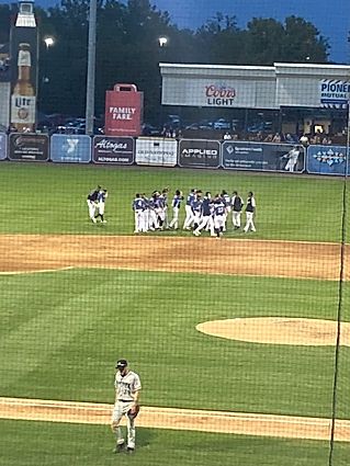 A group of baseball players are standing on a baseball field.