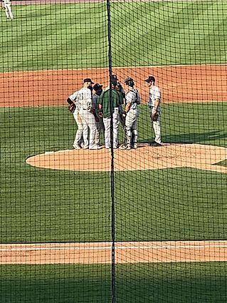 A group of baseball players are standing on a baseball field.