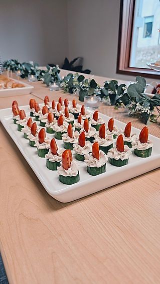 A white plate topped with cucumber slices and tomatoes on a wooden table.