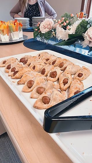 A white plate topped with cookies and tongs on a table.