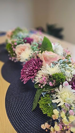 A bunch of flowers are sitting on a black placemat on a table.