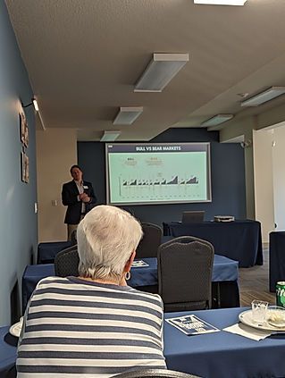 A man is giving a presentation to a group of people in a conference room.