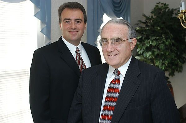 Two men in suits and ties are standing next to each other