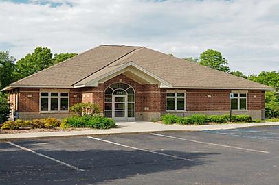 A brick building with a parking lot in front of it