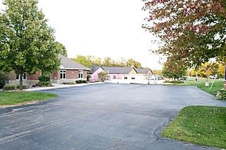 A parking lot with a few houses in the background