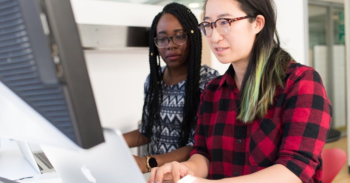 Two women are looking at a computer screen together.