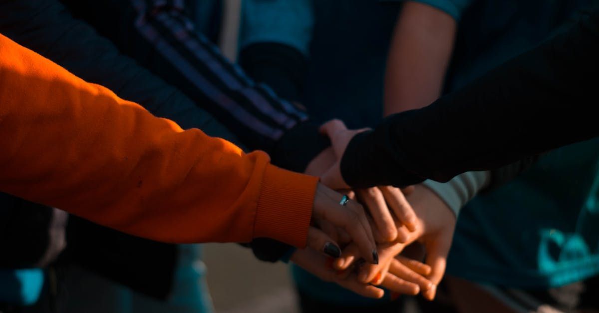 A group of people are putting their hands together.