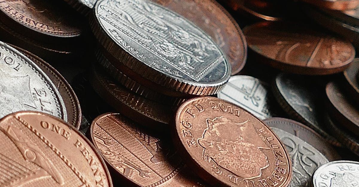 A pile of coins including a penny and a quarter are stacked on top of each other.