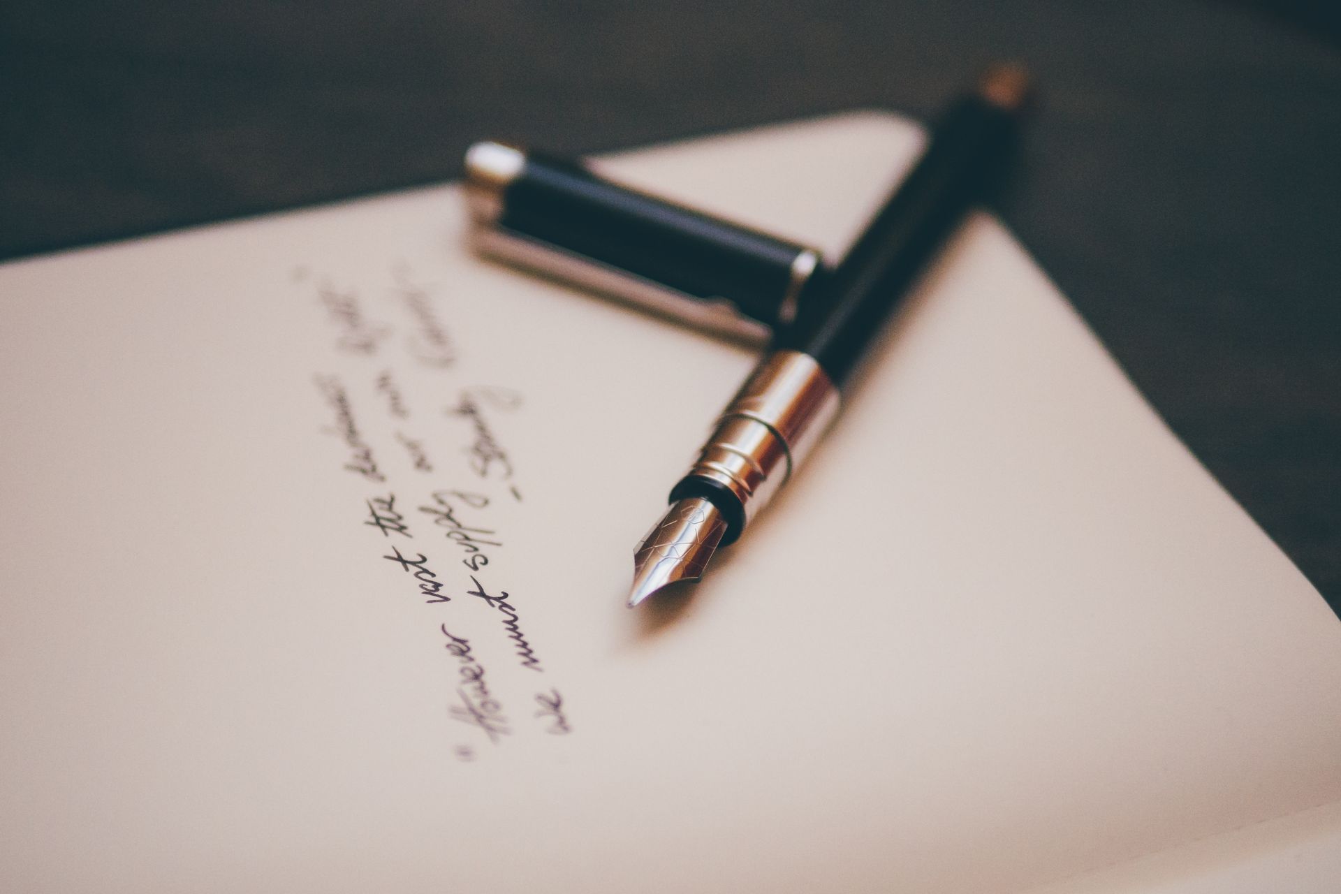 A fountain pen is sitting on top of a piece of paper